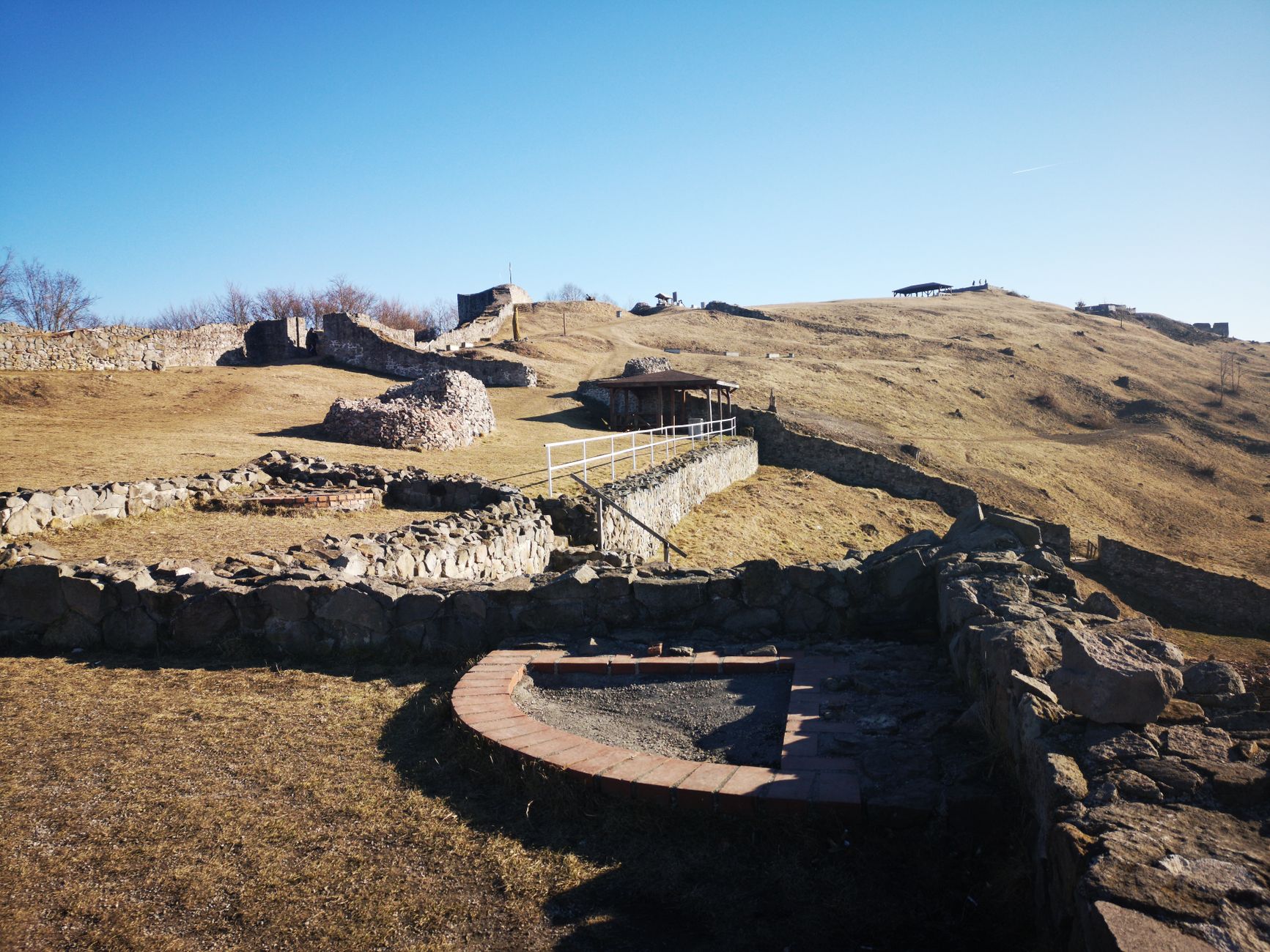 Kamenné ruiny Great Zimbabwe s mohutnou zdí postavenou bez malty v travnaté krajině
