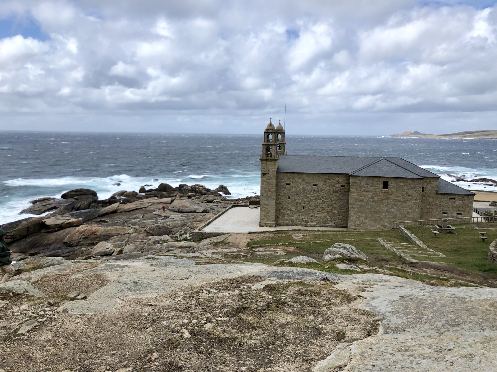 Kamenný kostel Santuario da Virxe da Barca v Muxíi na holých skalách přímo nad rozbouřeným Atlantikem